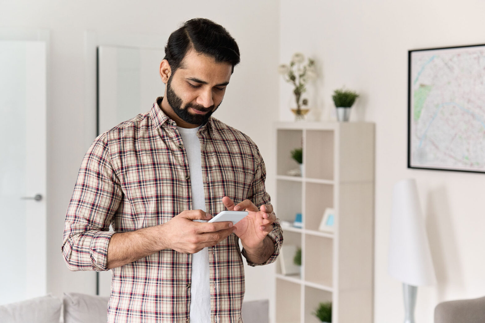 young-indian-man-holding-smartphone-using-cell-pho-2021-09-02-15-13-50-utc